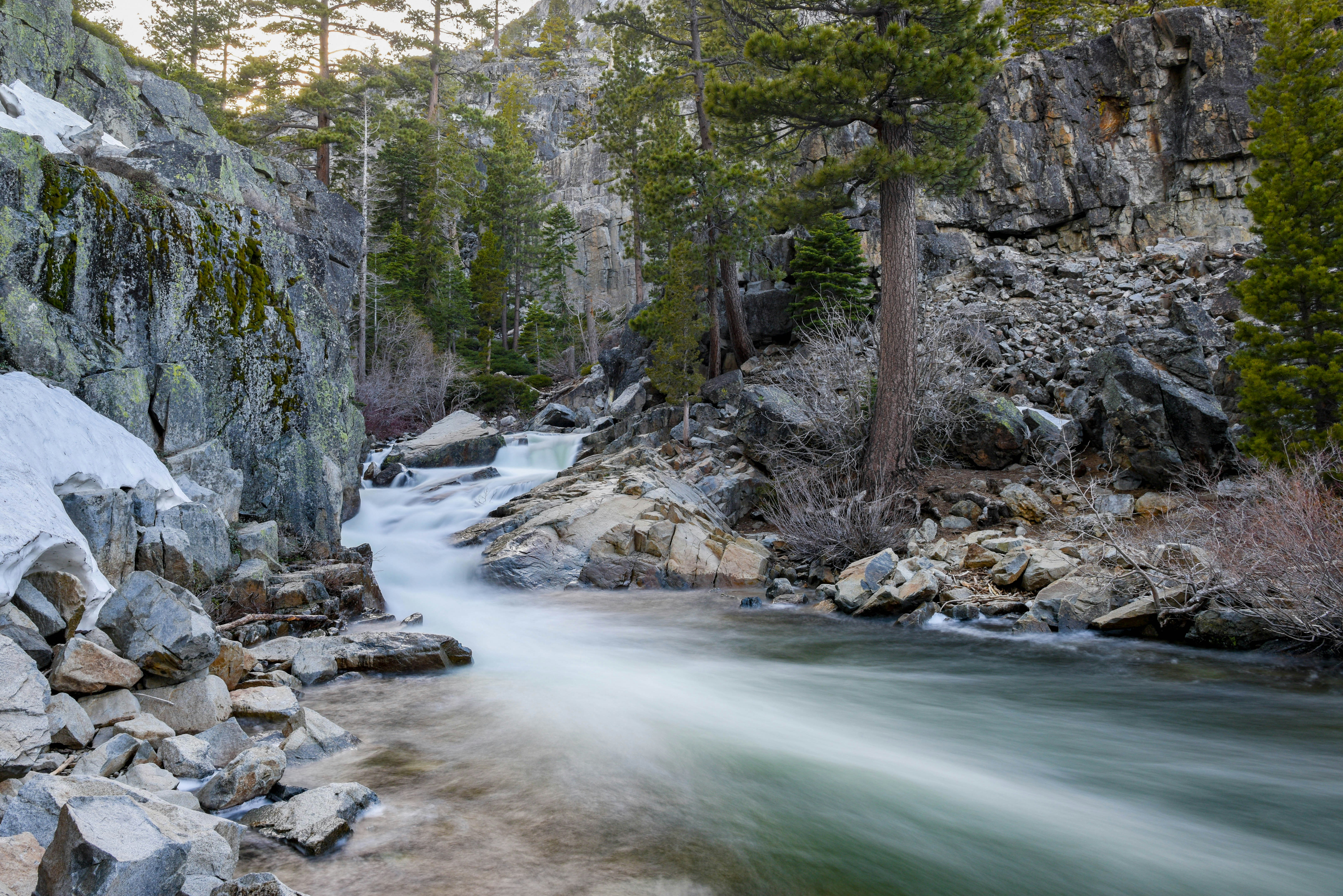 timelapse photography of river flowing between gray rock formations